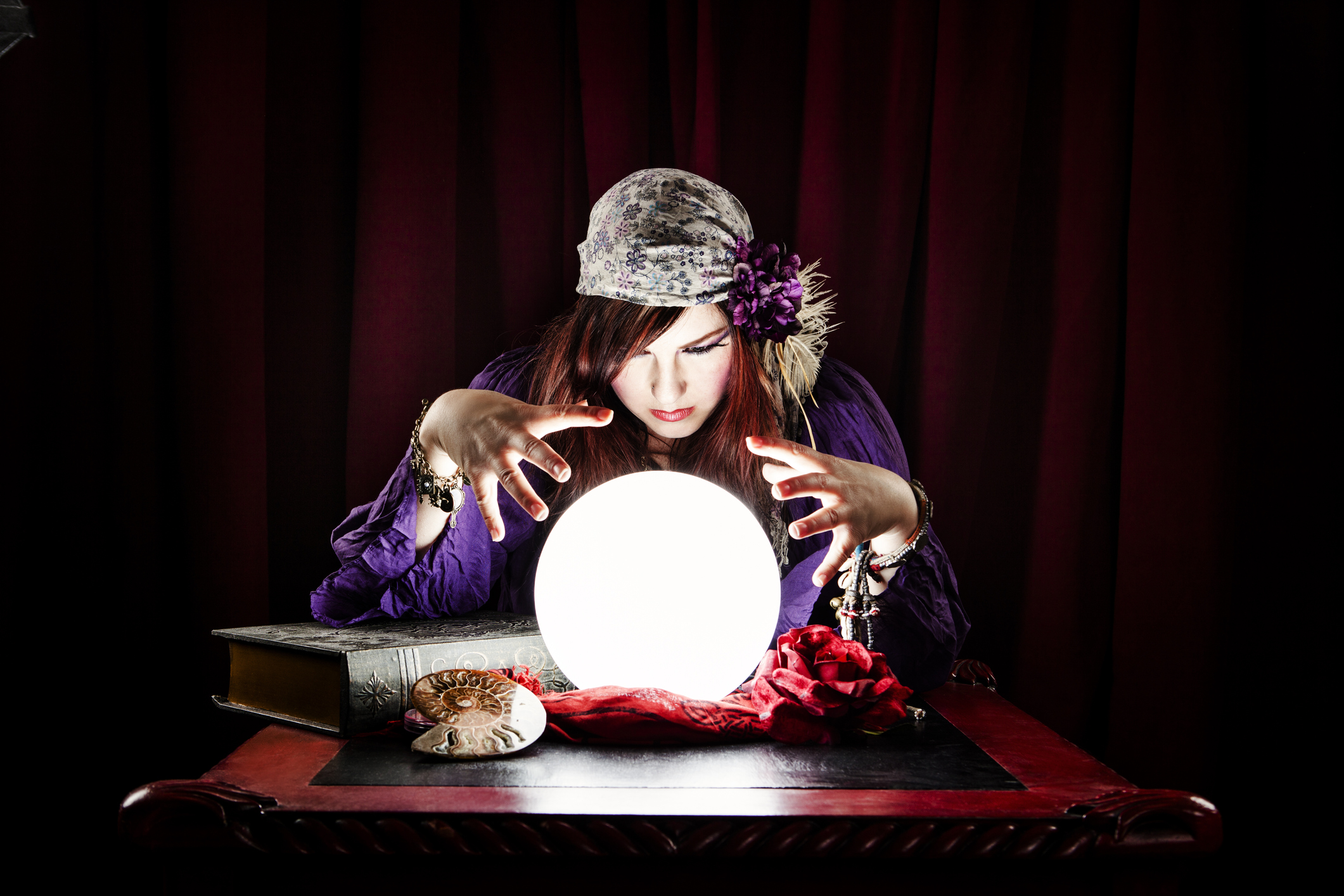A psychic woman trying to talk to spirit using a crystal ball