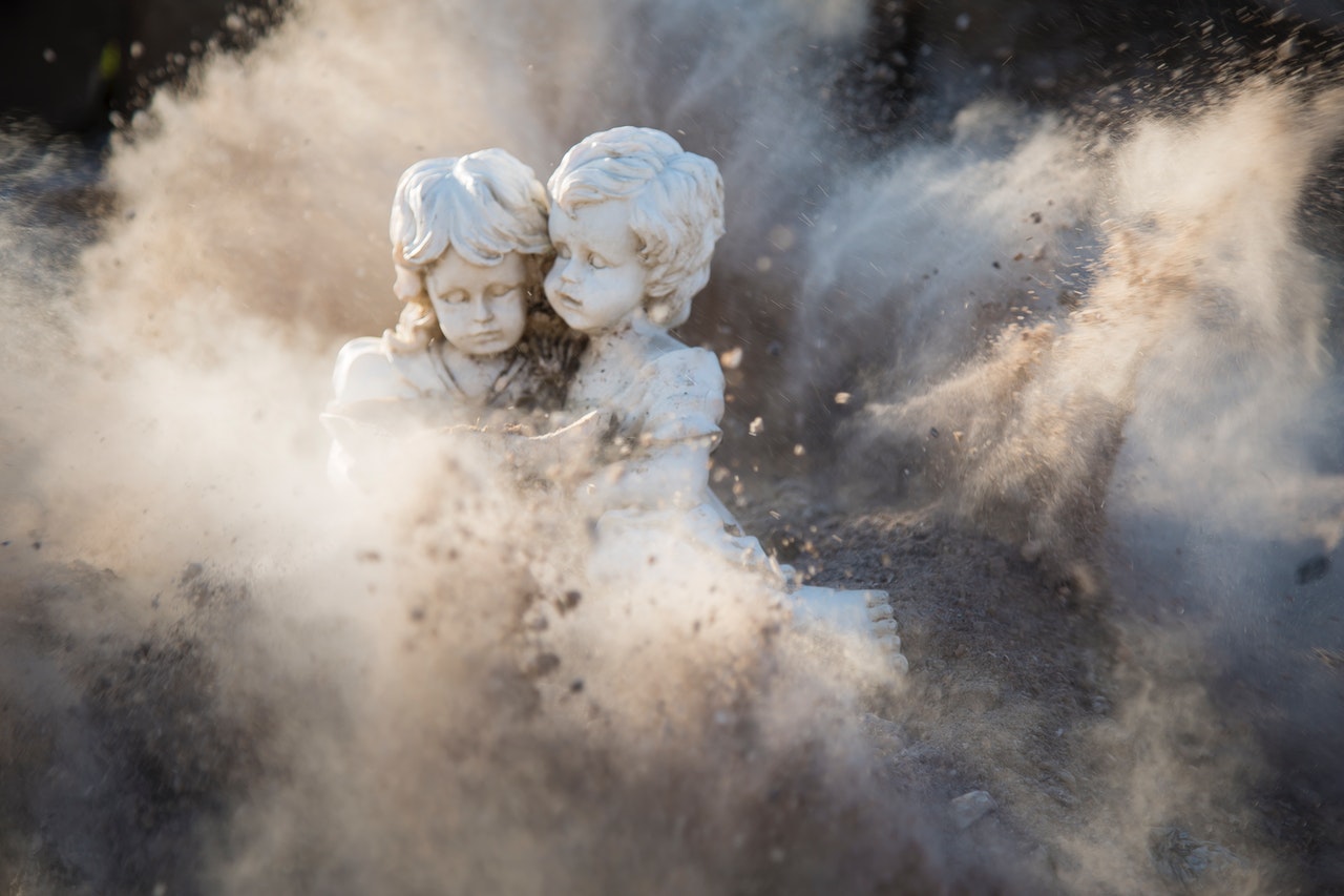 Two White Concrete Angel Statues Covered by Dust