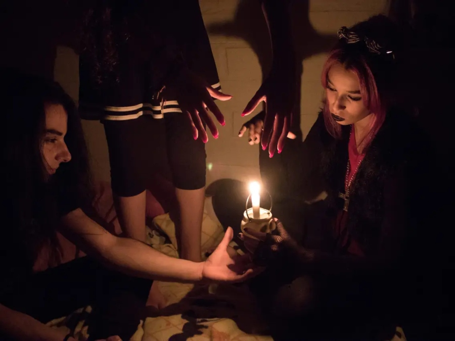 Some modern-witches holding a candle