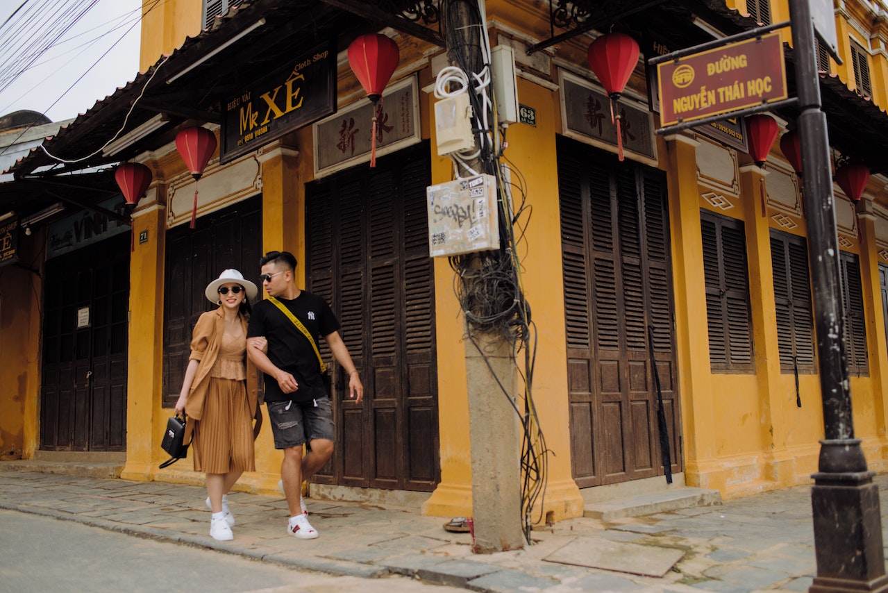 Stylish Asian couple walking on Asian city street