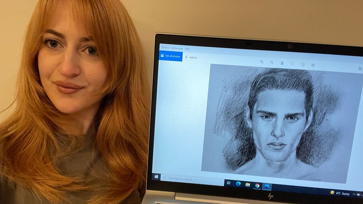A woman beside a laptop with a sketch of a man on the screen