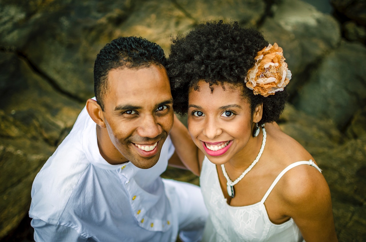 Man and Woman Smiling While Standing on Rocks