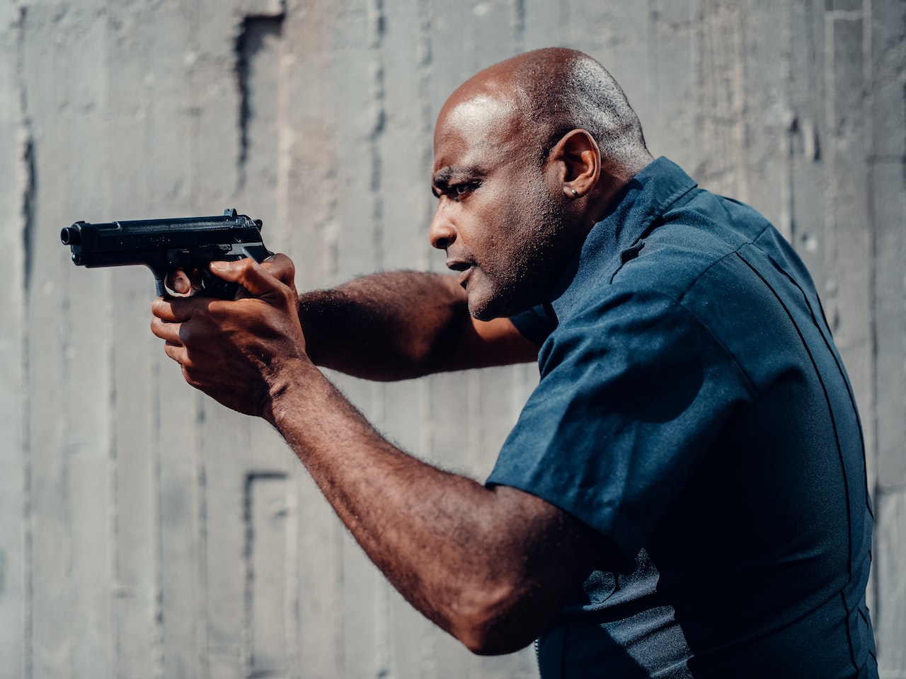 Man in Blue Uniform Holding a Gun
