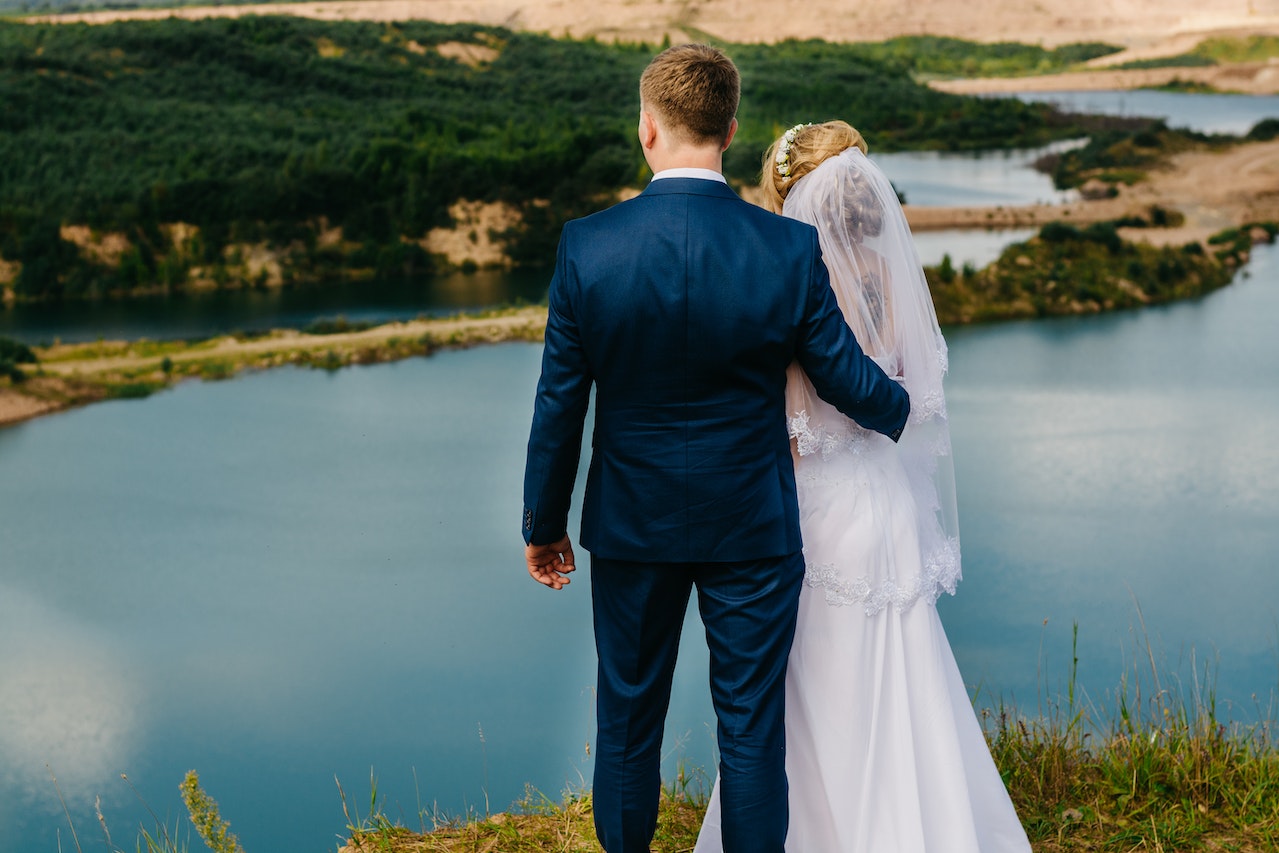 Bride and Groom Standing Near Body of Water