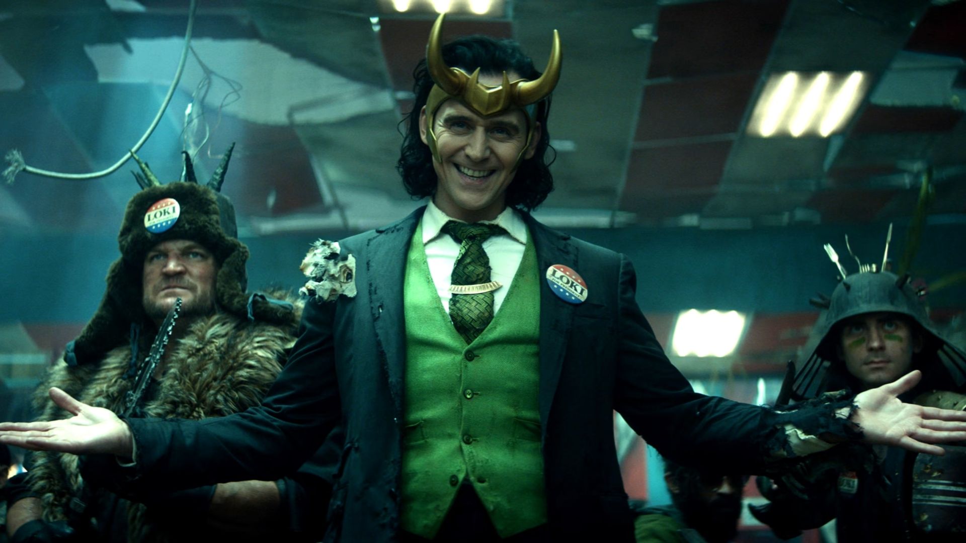 Loki from Marvel dressed in a suit while wearing his golden horn, smiling
