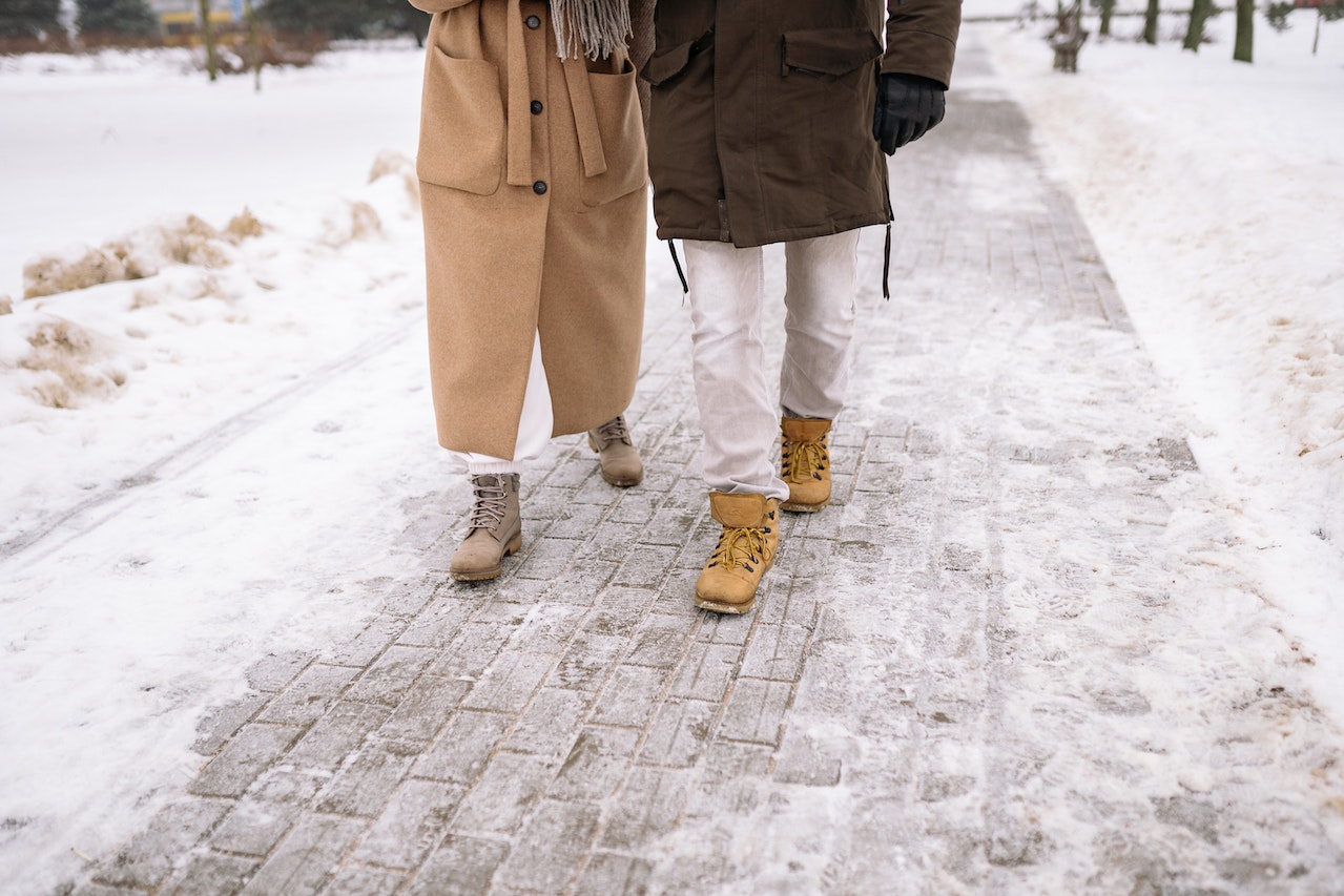 A Couple Walking on Snow Covered Ground