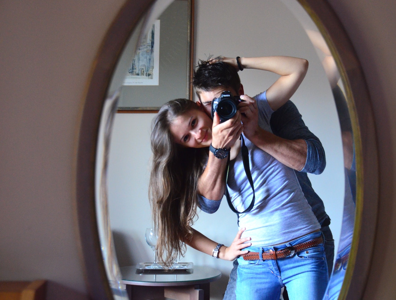 Man and Woman Taking Photo in Front of Mirror