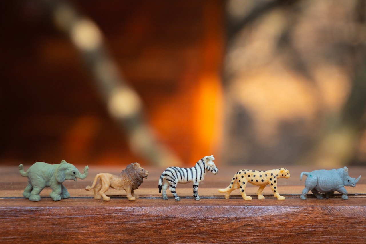 Plastic Animal Toys Lined Up on a Wooden Surface