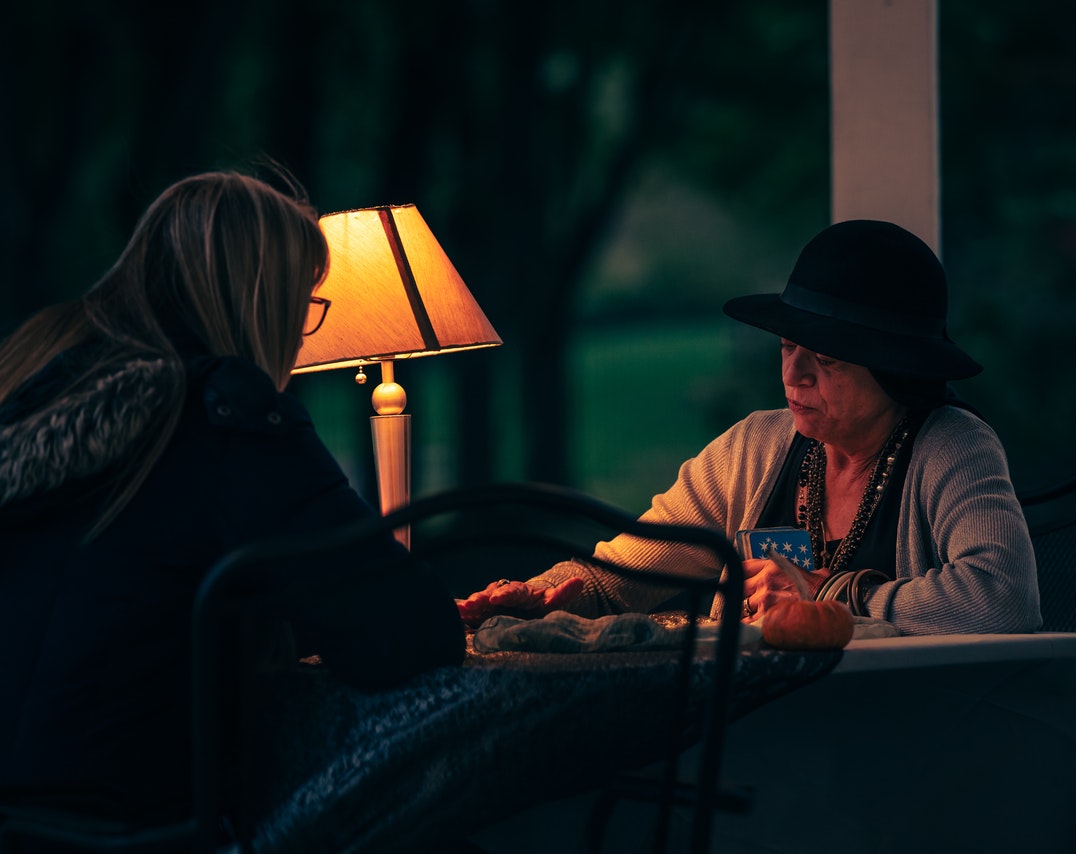 A Woman Reading Tarot Cards To Her Client