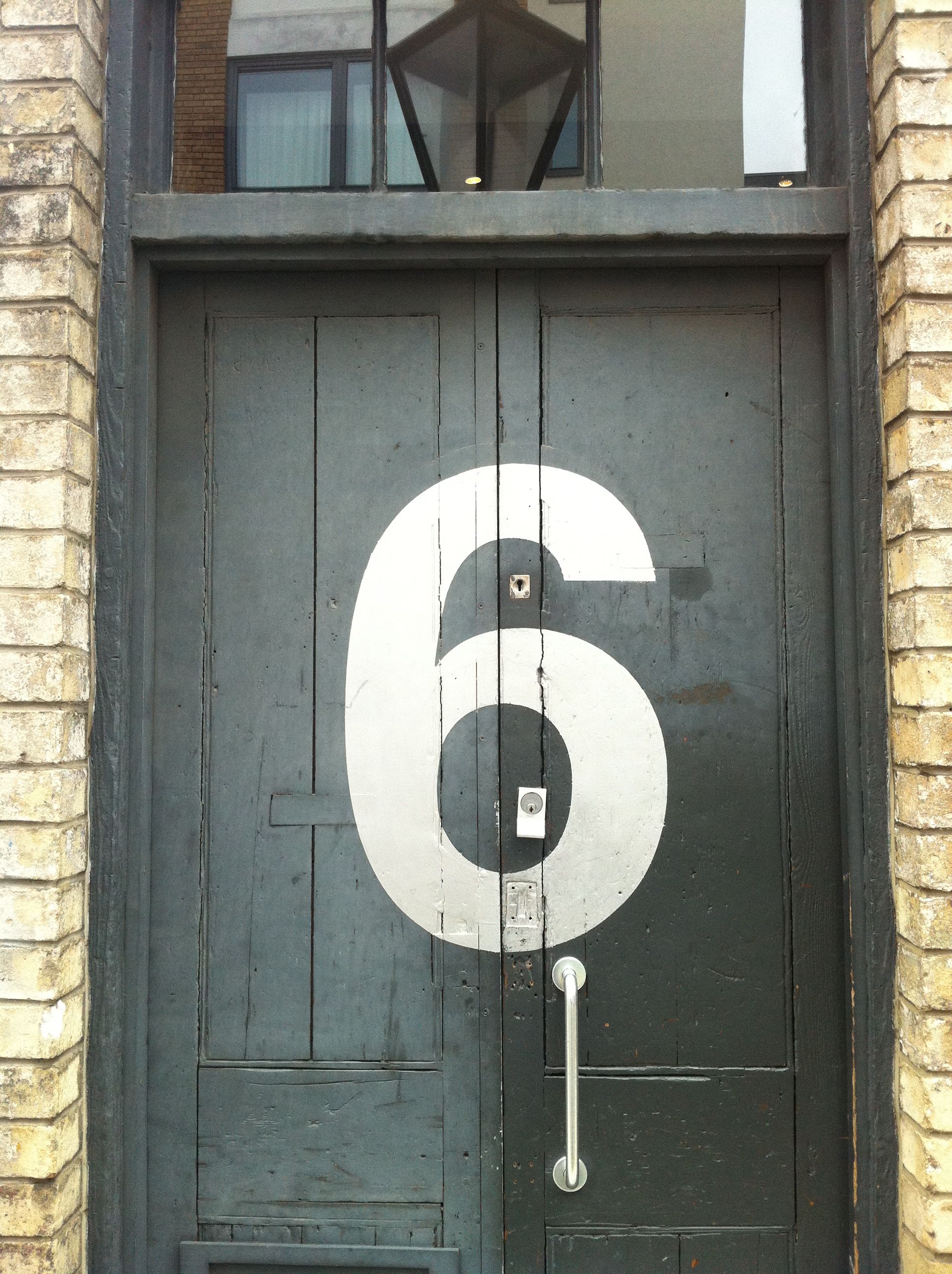A big black door with number 6 white paint