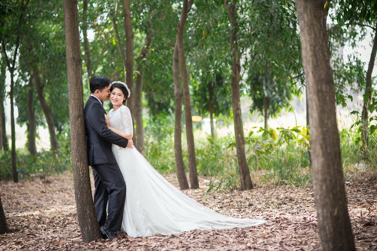 Bride and Groom Hugging While Leaning On A Tree