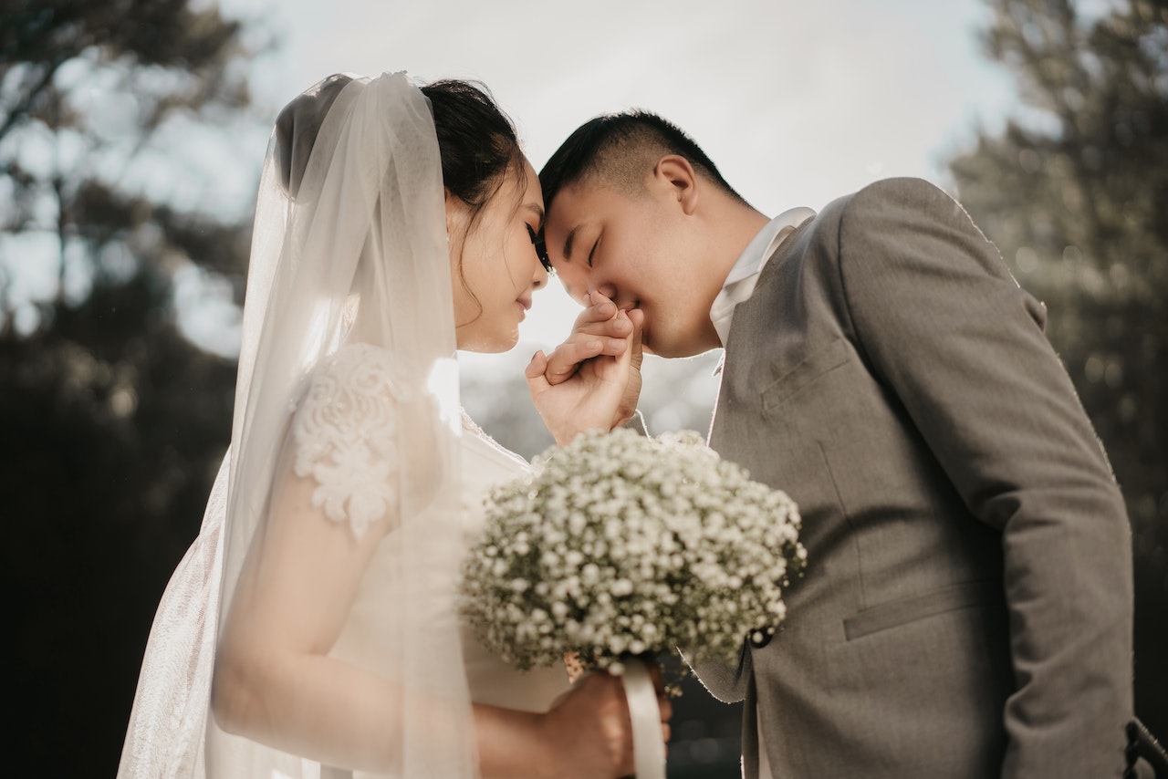 A Groom Kissing the Hand of His Bride