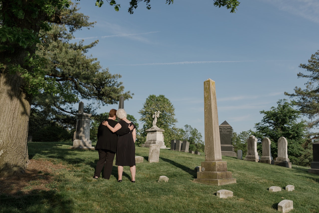 Two Women Comforting Each Other at a Cemetery