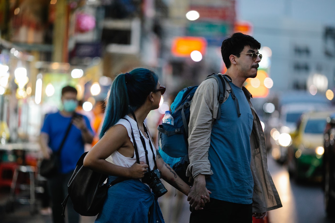 A Couple Holding Hands While Walking In The Streets
