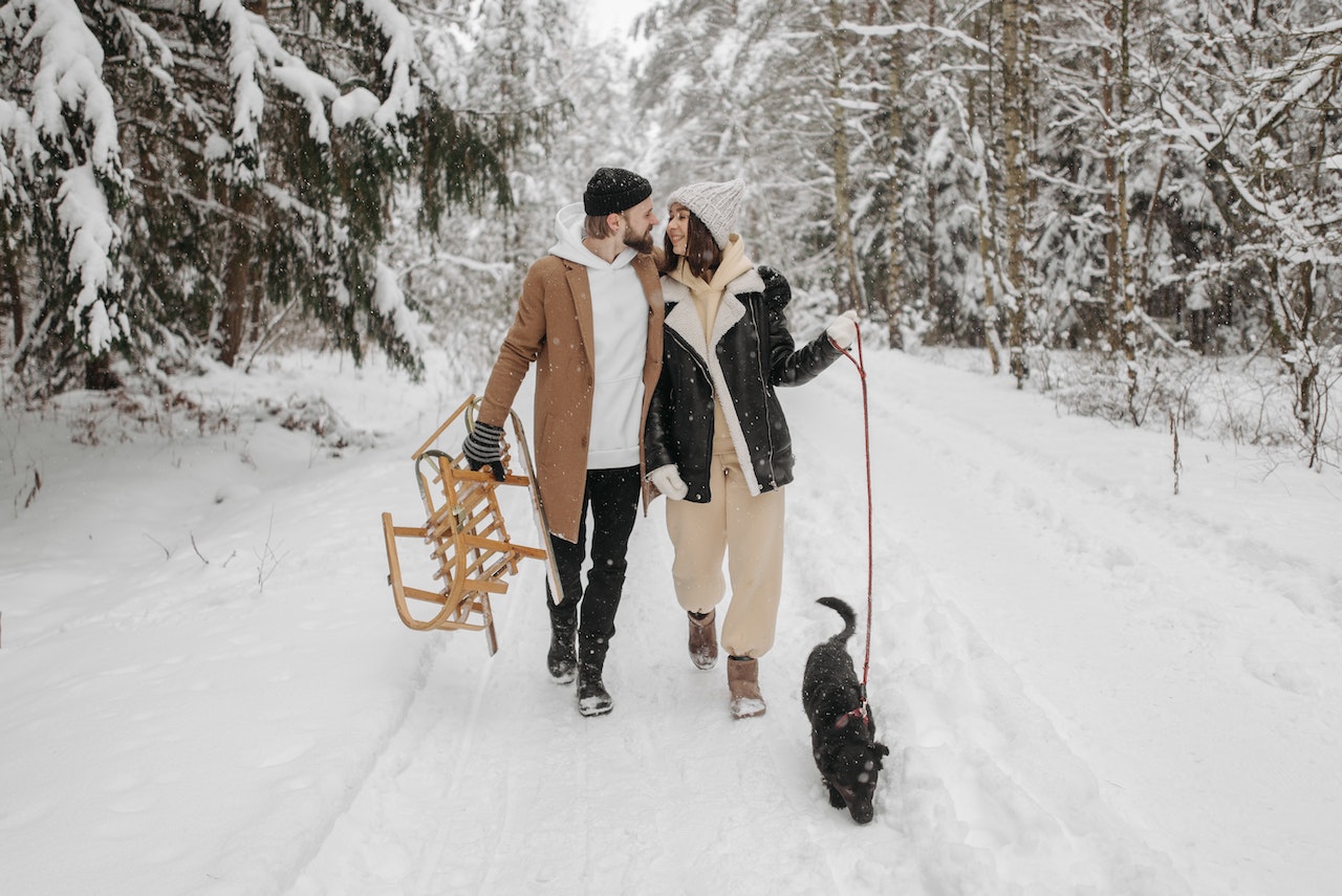 A Couple Walking Their Pet Dog during Winter