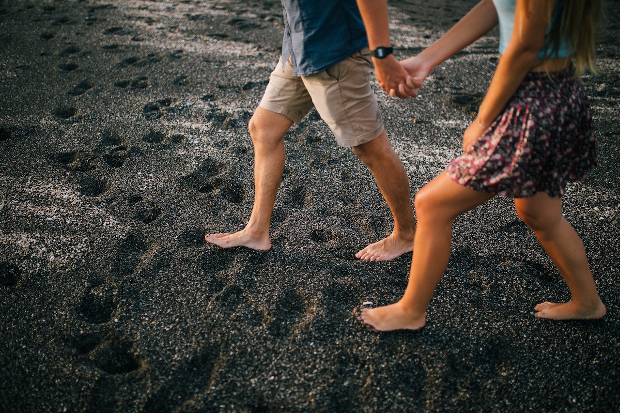 Young Couple Holding Hands On Beach