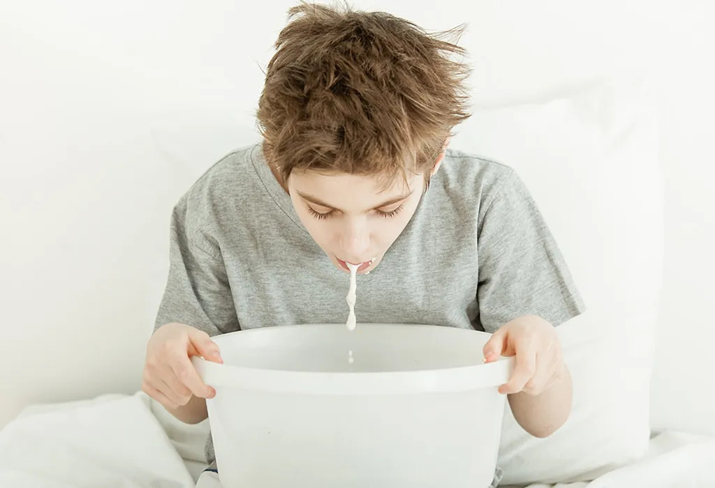 A boy puking white stuff on a white basin