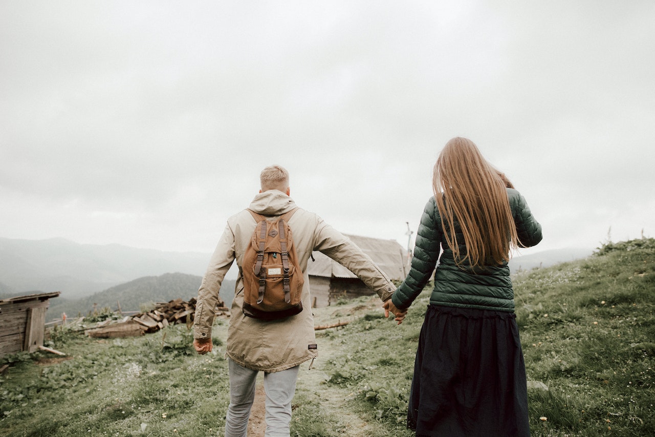 Man and Woman Walking Towards A Wooden Shed Holding Hands