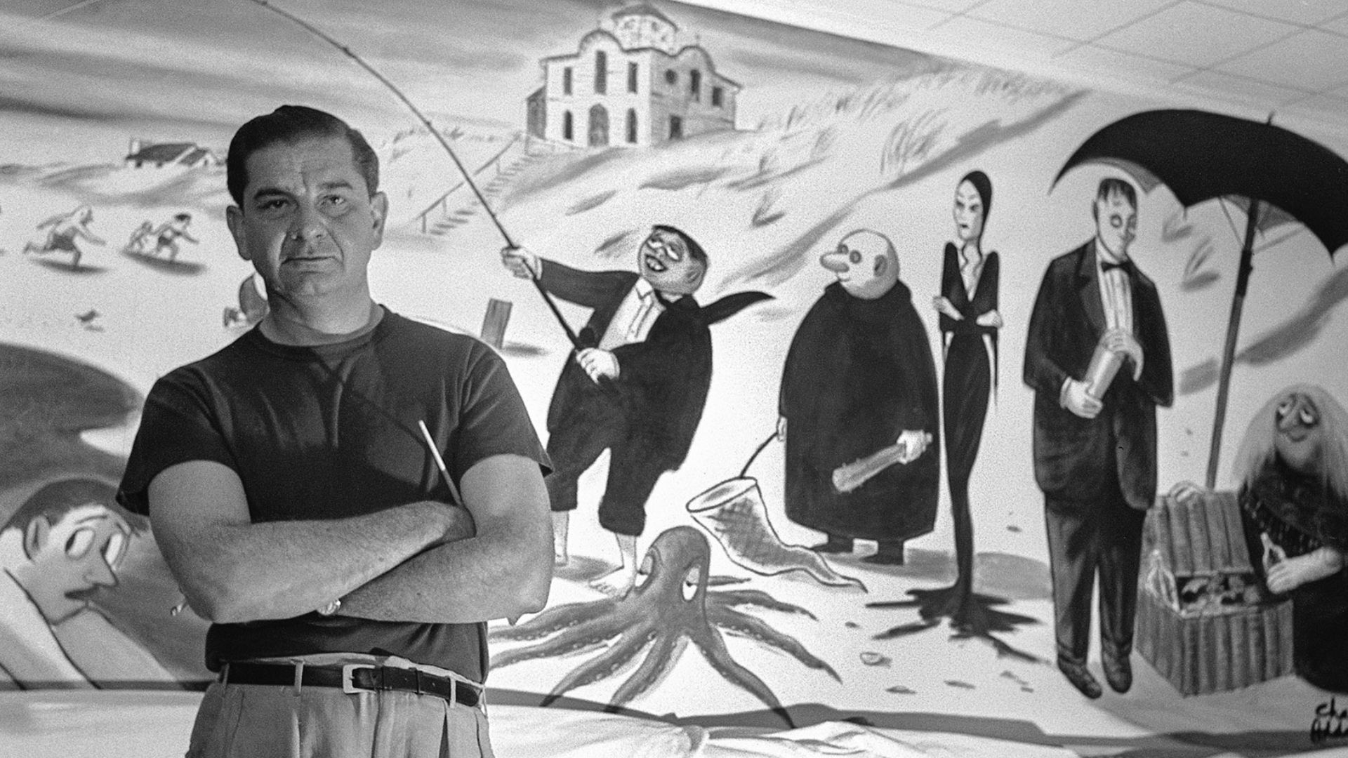 Charles Addams With His Arms Crossed In Front Of A Painting