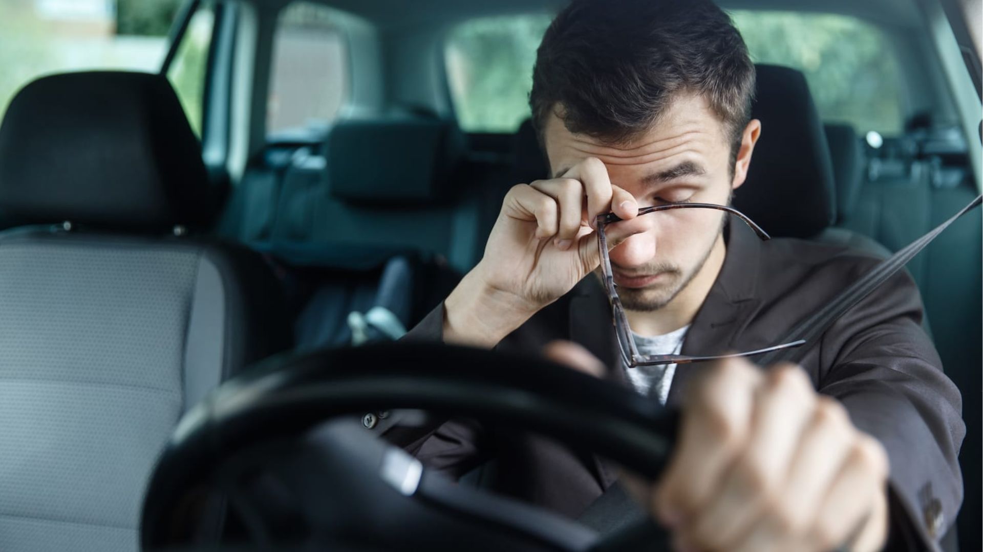 A Person Rubbing His Eyes while driving