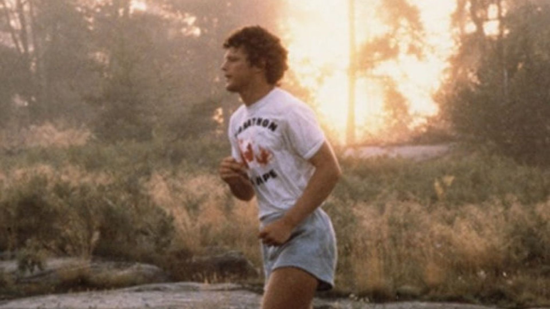 Terry Fox Running In A white shirt and Gray Shorts
