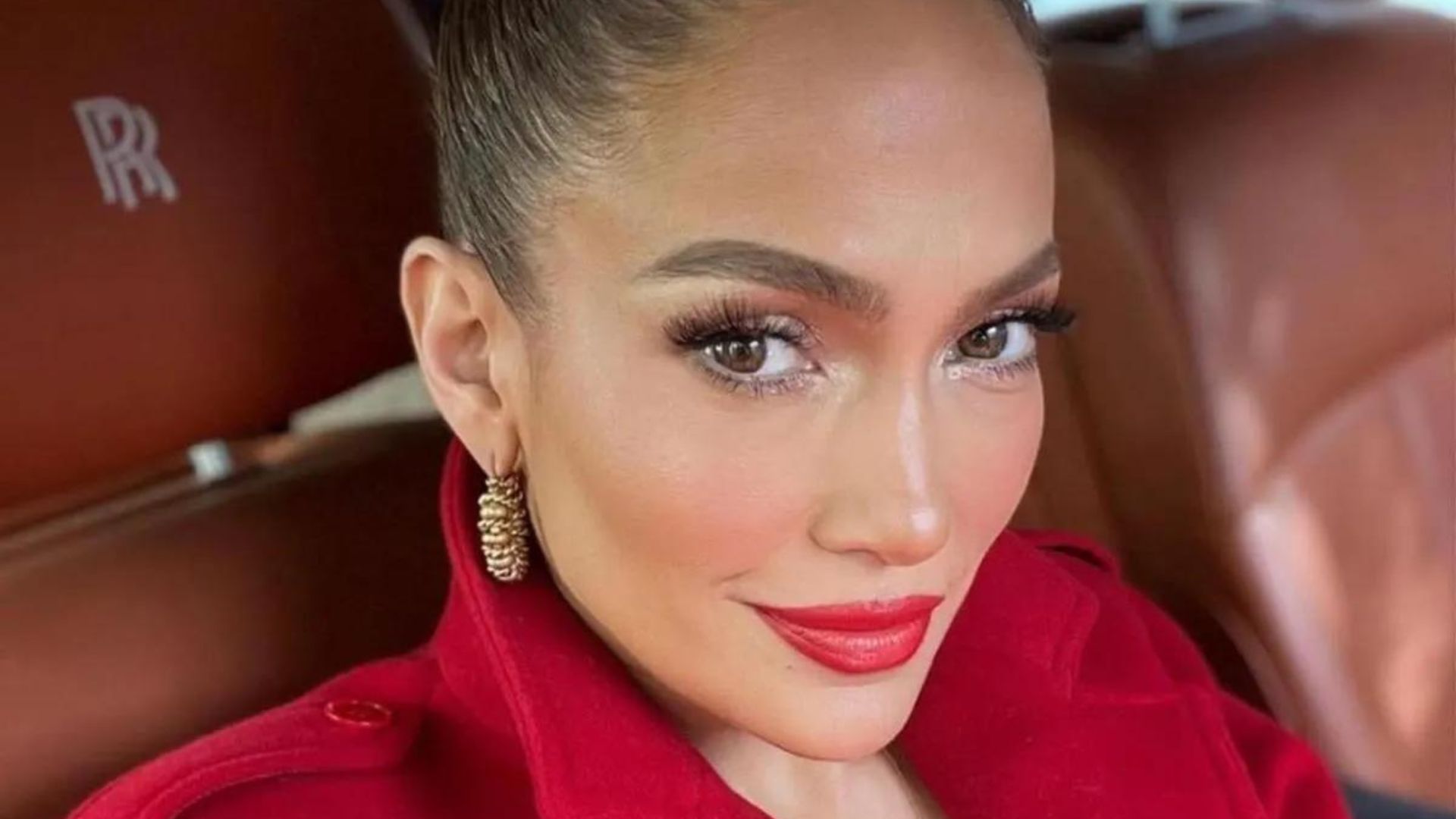 Jennifer Lopez in a Car Seat, Wearing A Red Coat