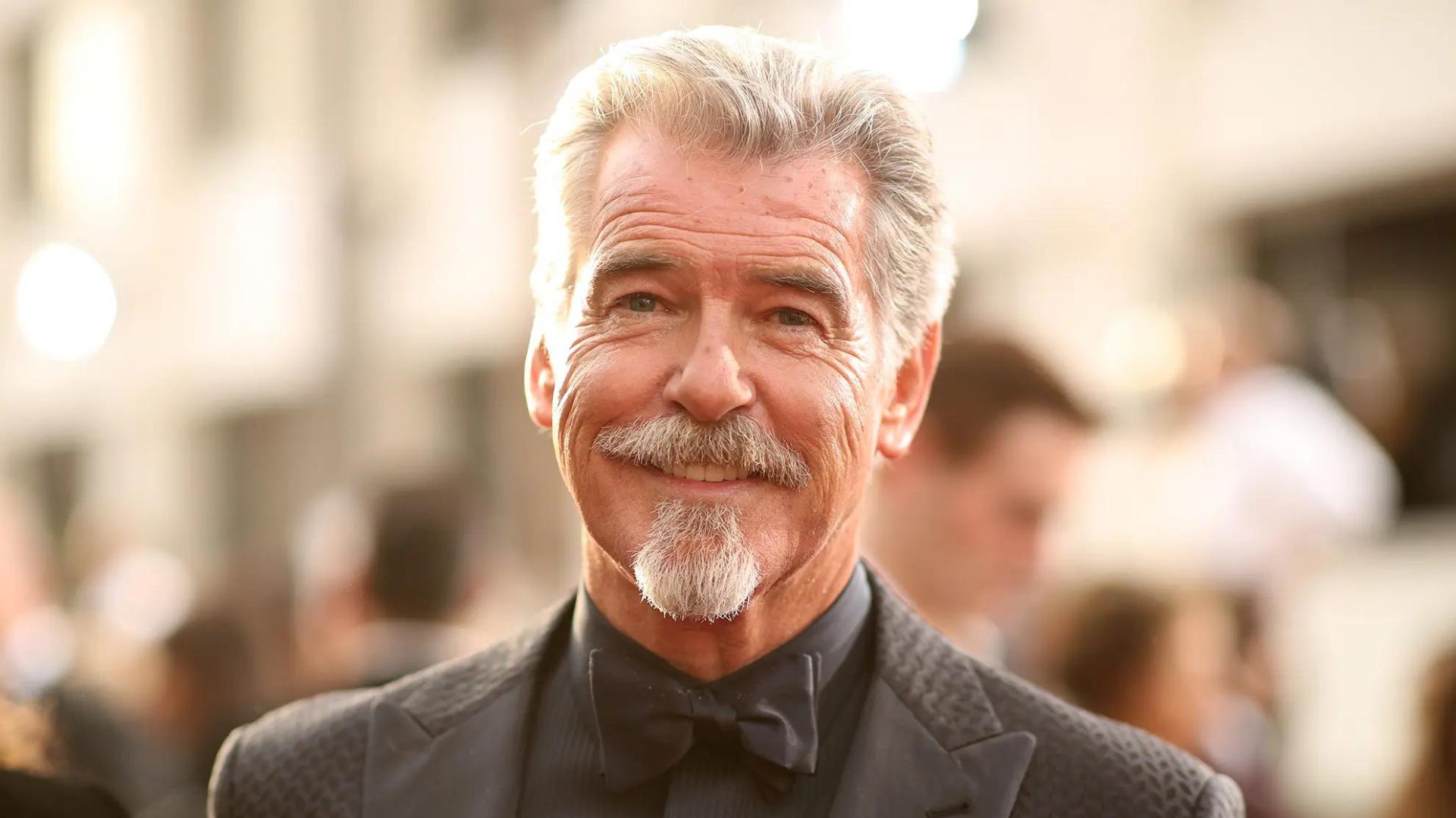 Pierce Brosnan Smiling And Wearing A Suit with Bow Tie
