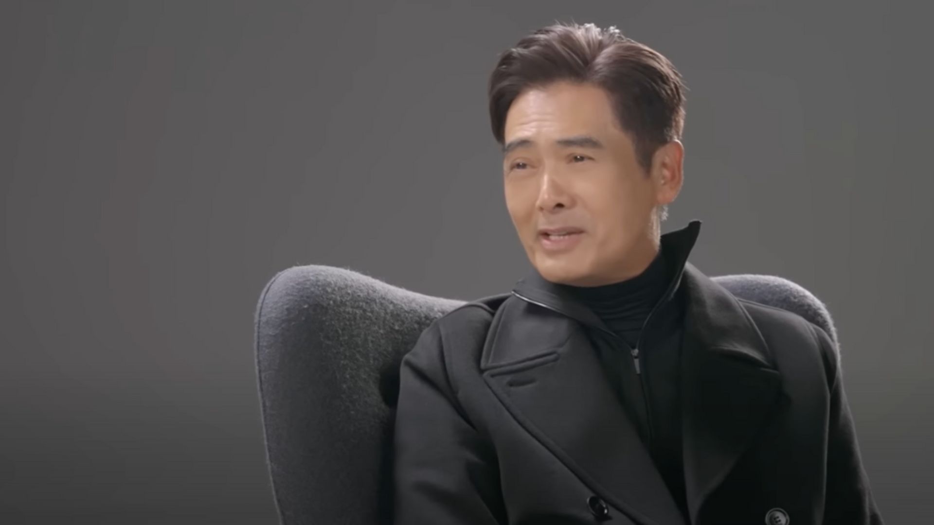 Chow Yun-Fat Siting On A Black Chair