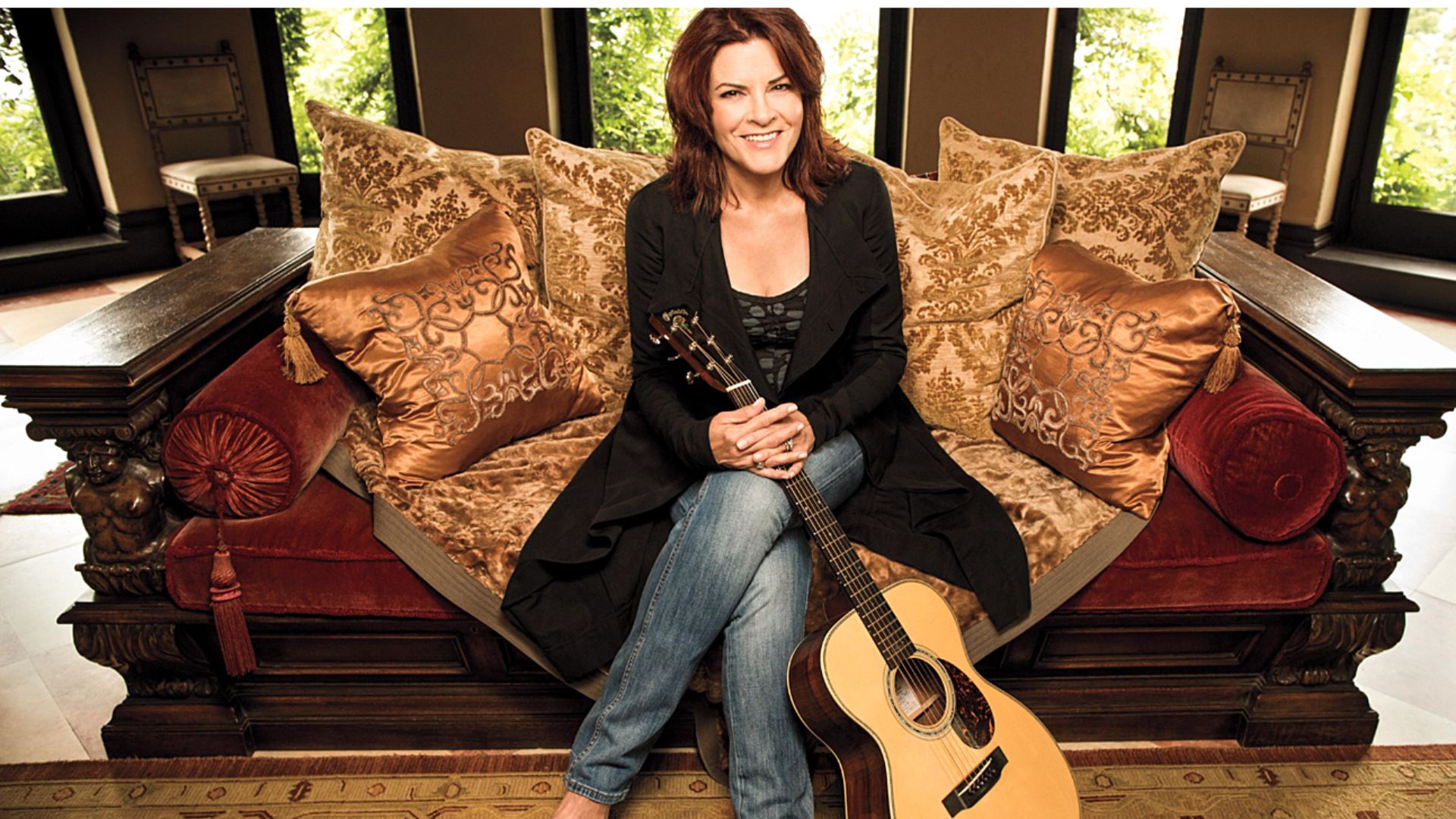 Rosanne Cash Sitting On Sofa With A Guitar In Hand