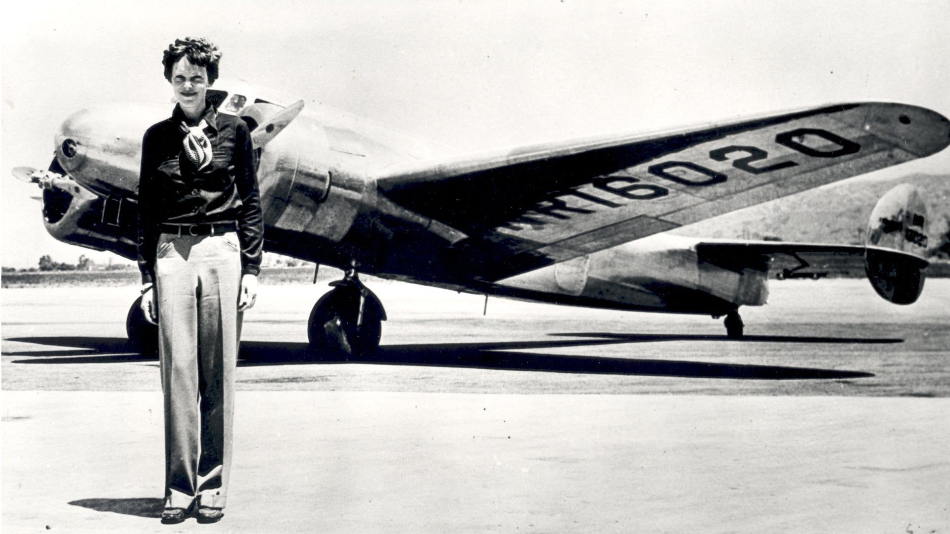 Amelia Earhart With A Plane Behind Her