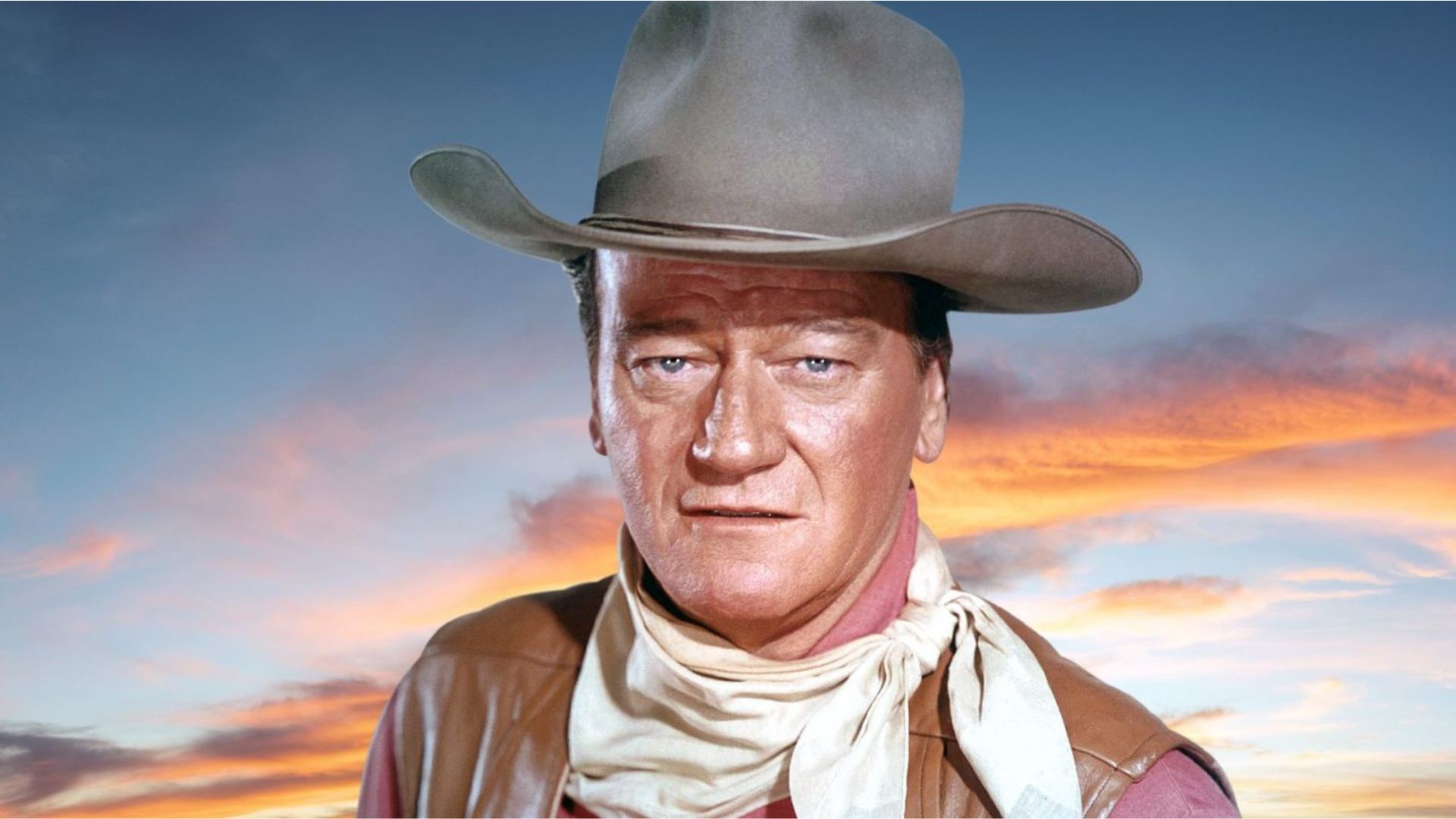 John Wayne Wearing A Gray Cowboy Hat And A Brown Vest