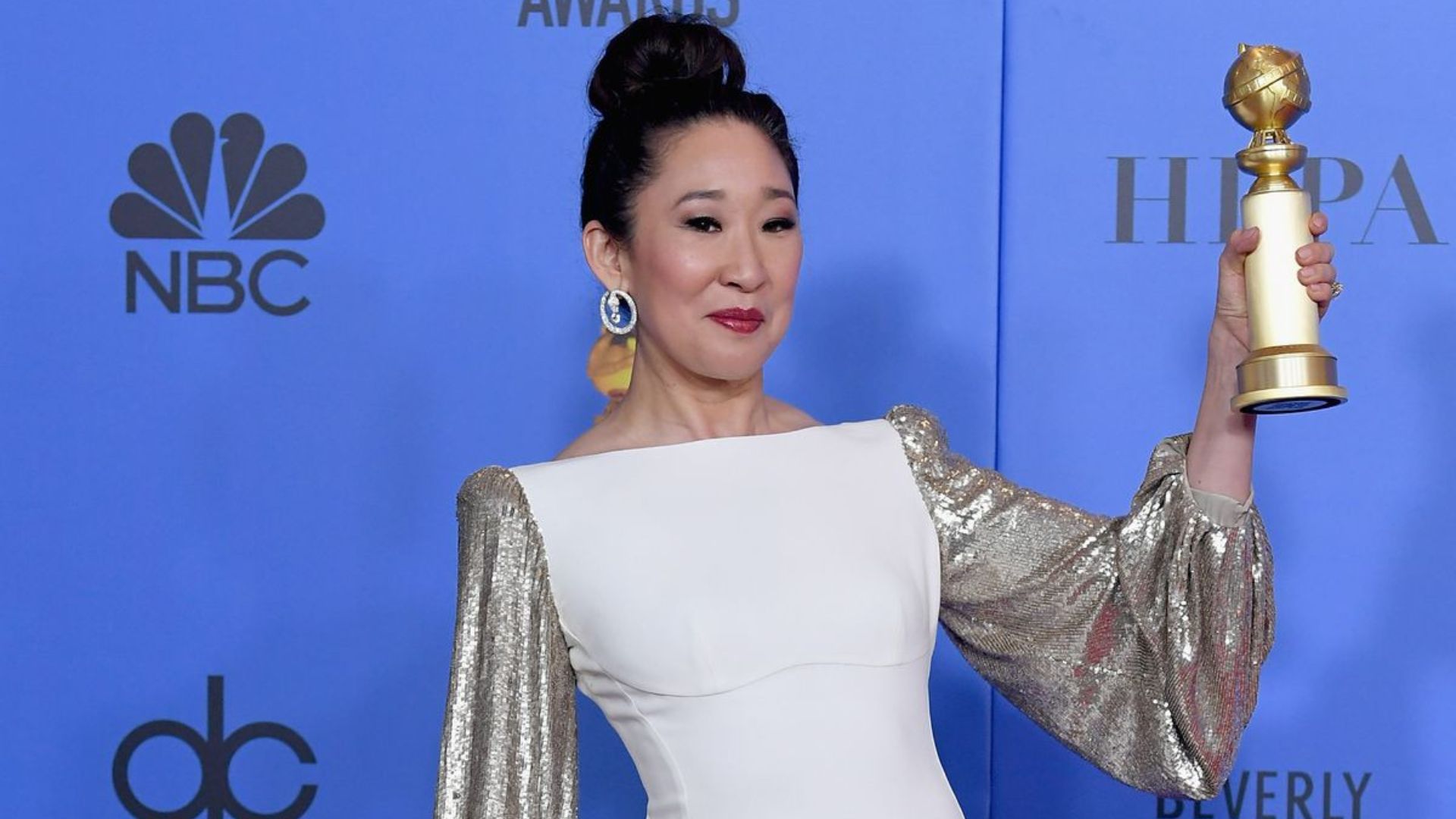 Sandra Oh Wearing White Dress And Holding A Trophy