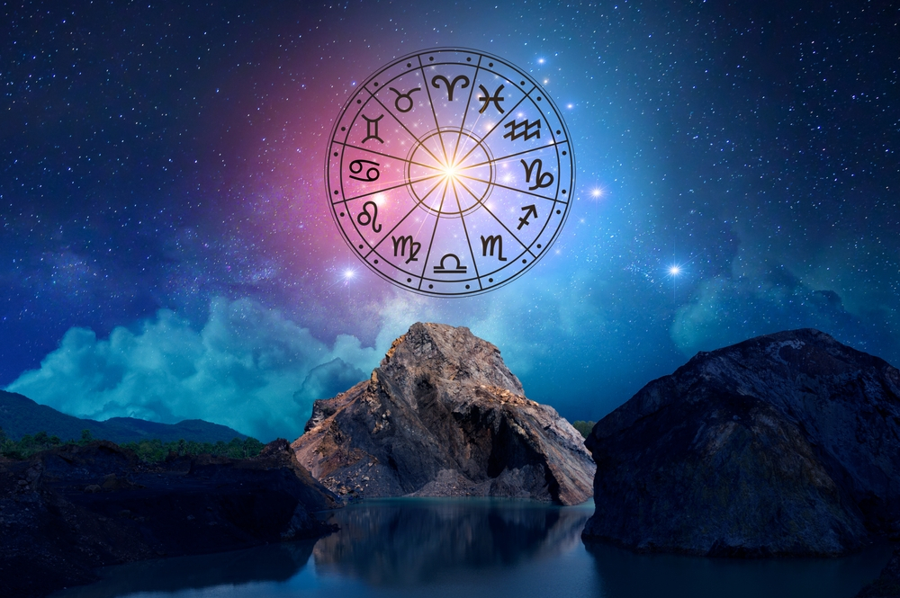 A zodiac wheel under a starry sky.