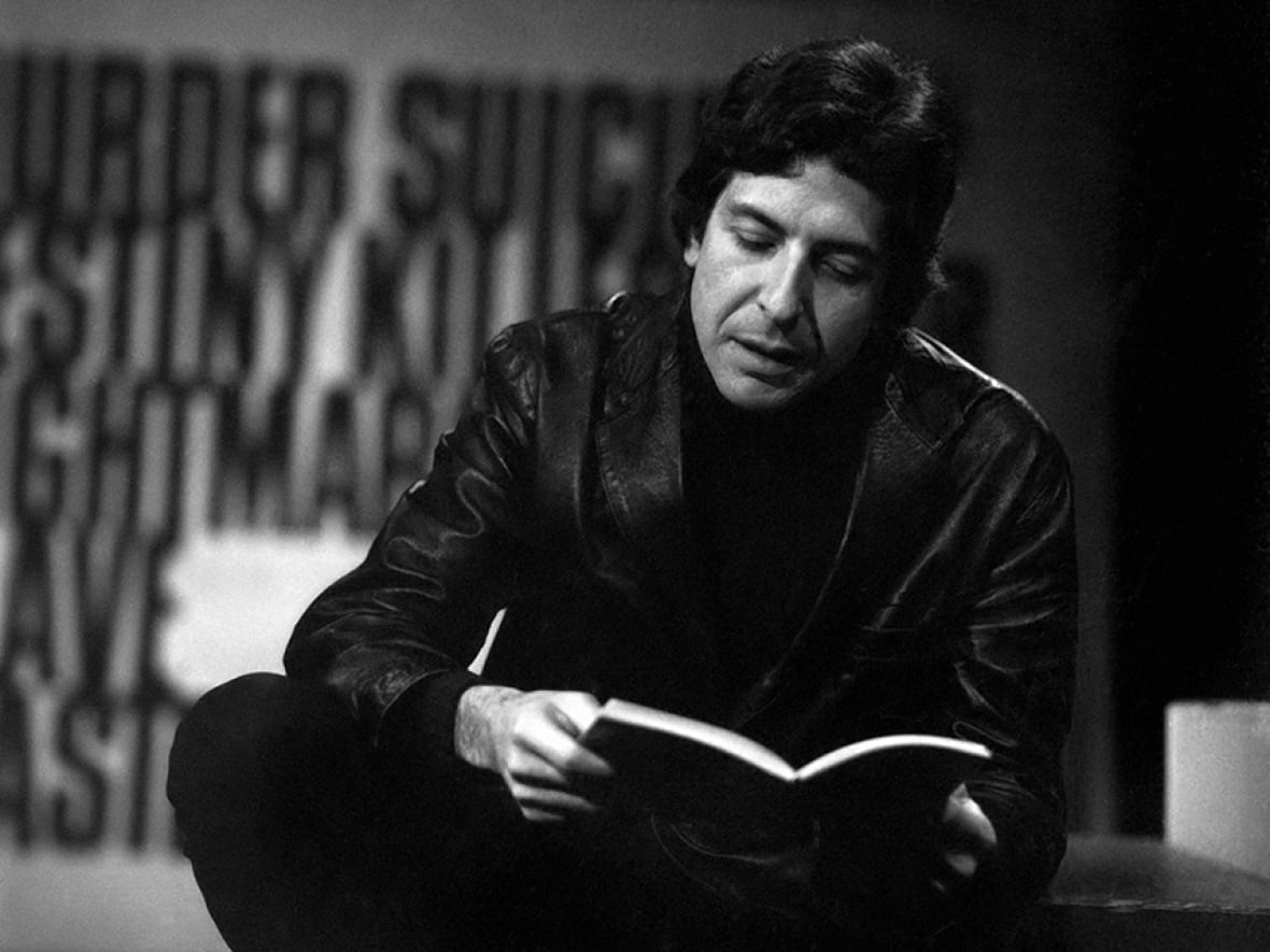 Leonard Cohen holding a book.