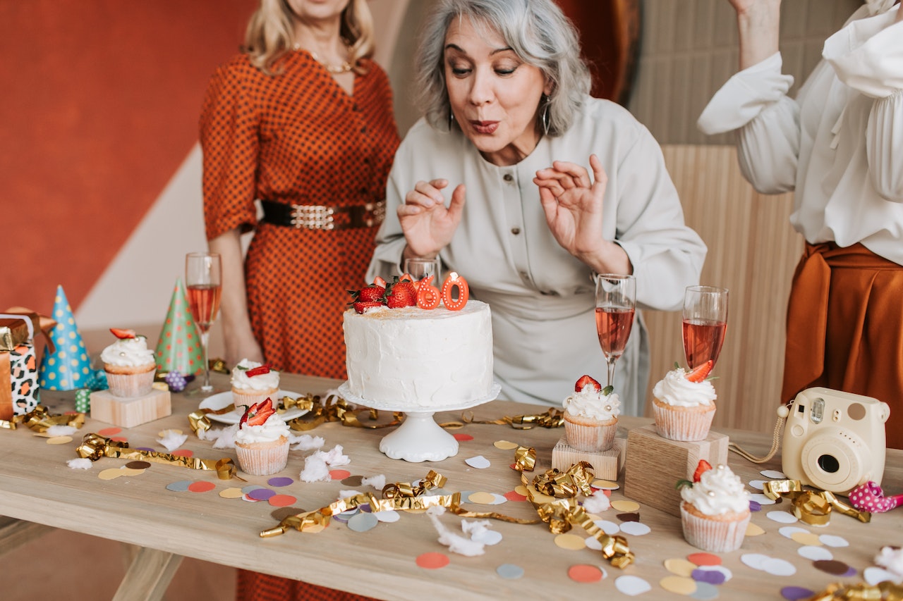 Boss Lady in a Gray Dress Blowing the Candles on a Cake