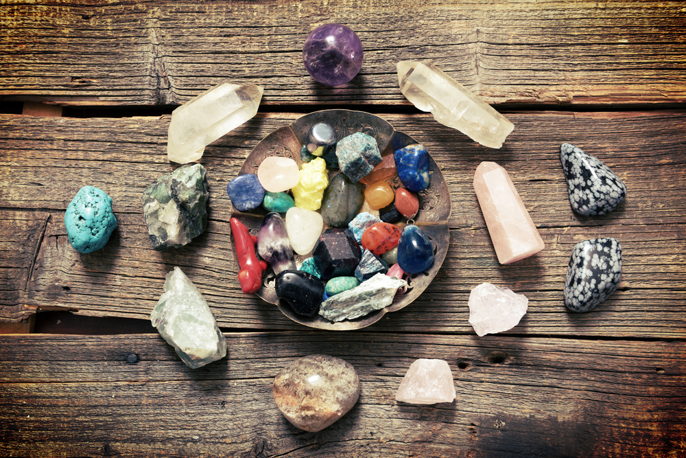 Multiple semi precious gemstones on a wooden table.