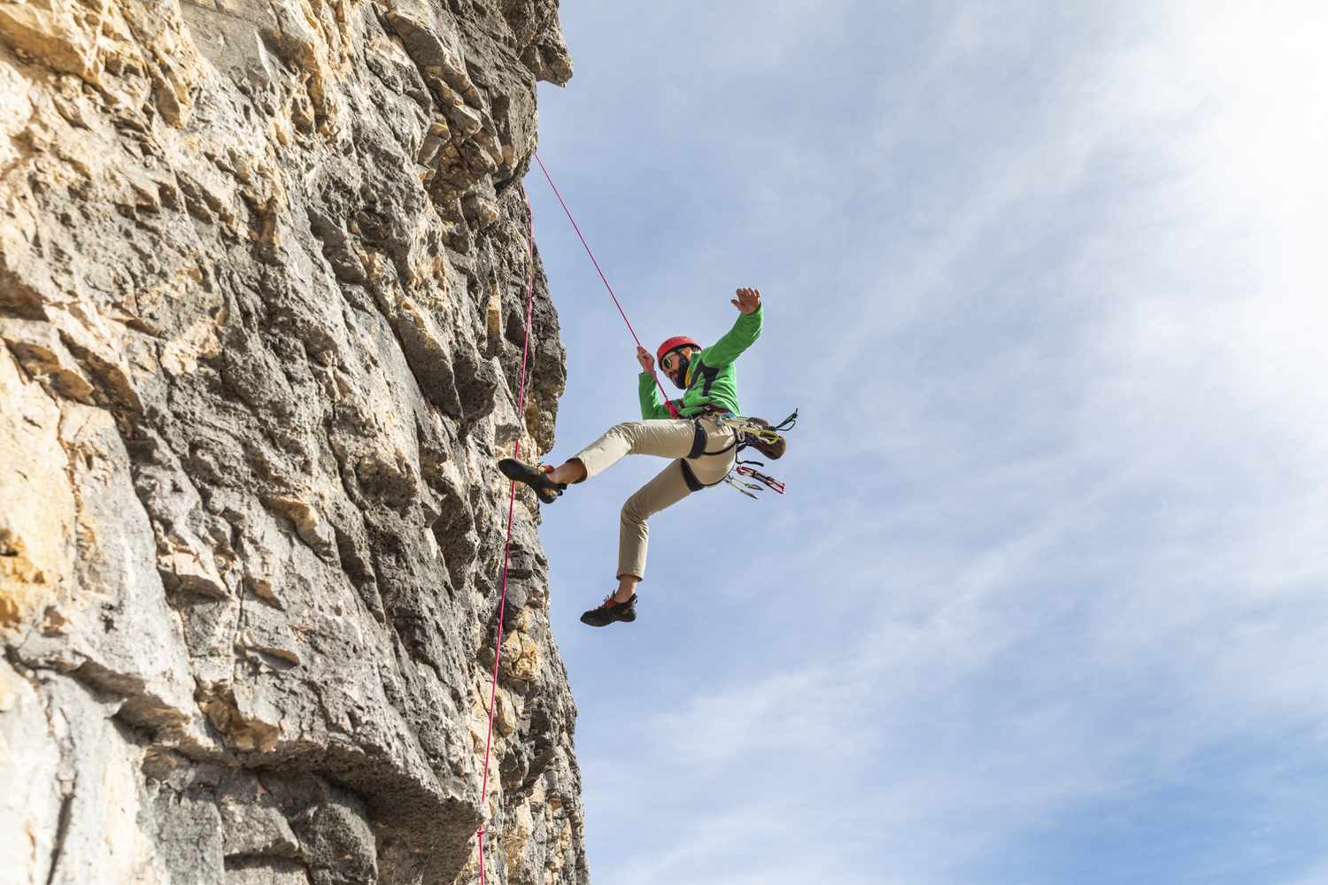 A Man Climbing A Mountain With The Help Of A Rope