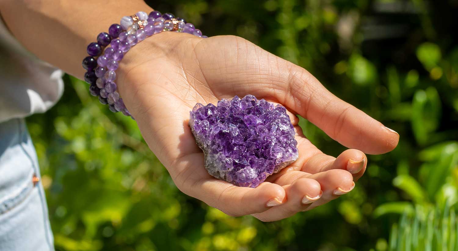 Woman's Hand Holding a Purple Crystal