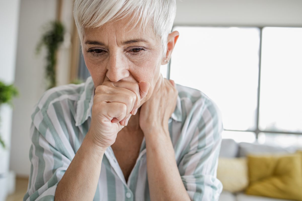 An Old Woman Coughing In Her Hands