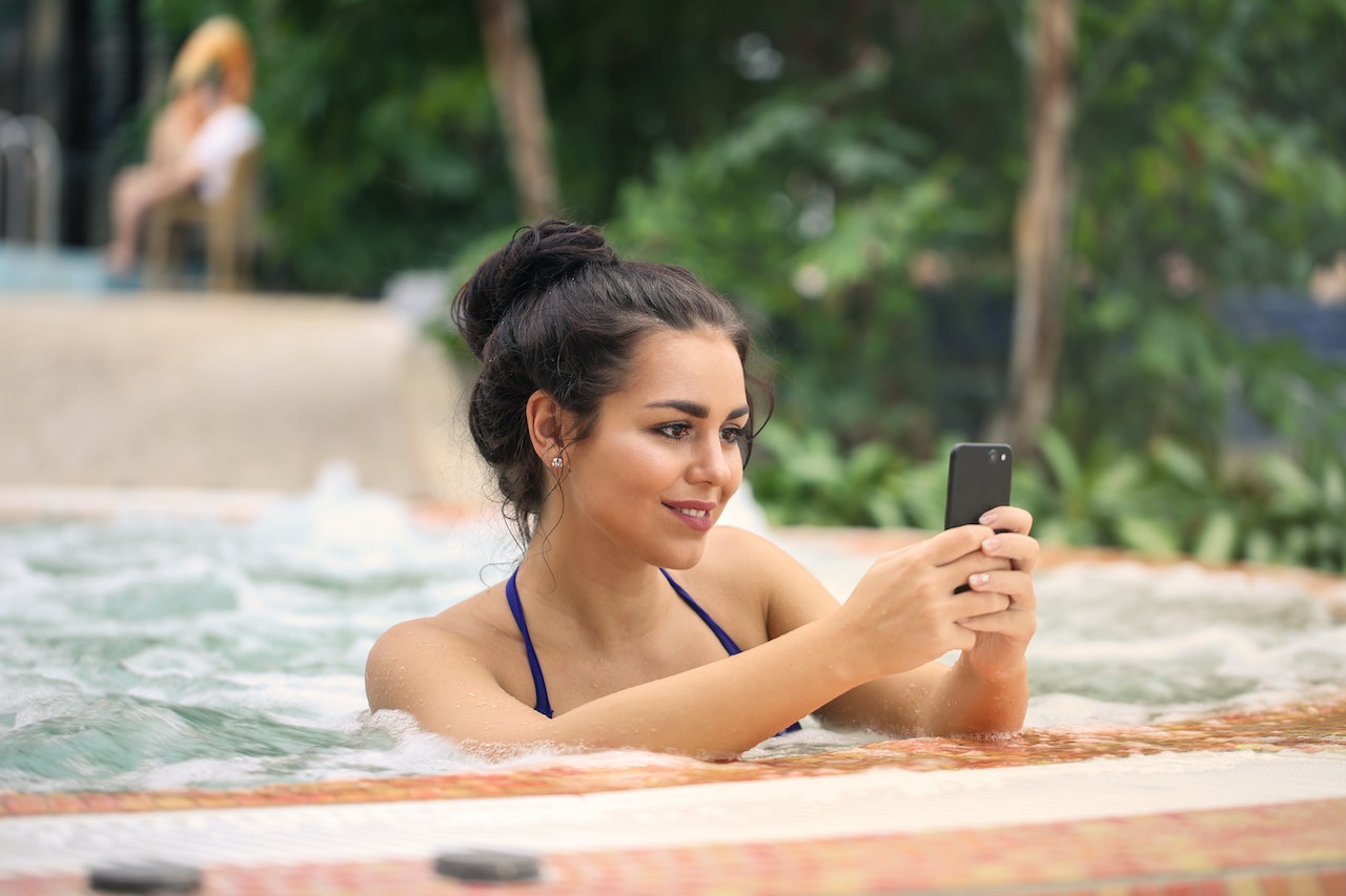Woman in Jacuzzi Using Smartphone