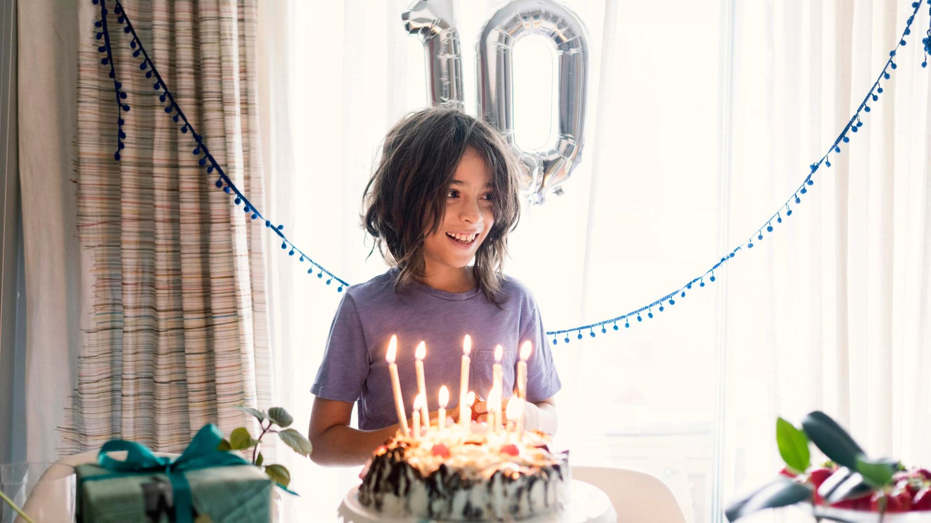 A Girl Holding A Cake With Candles On It