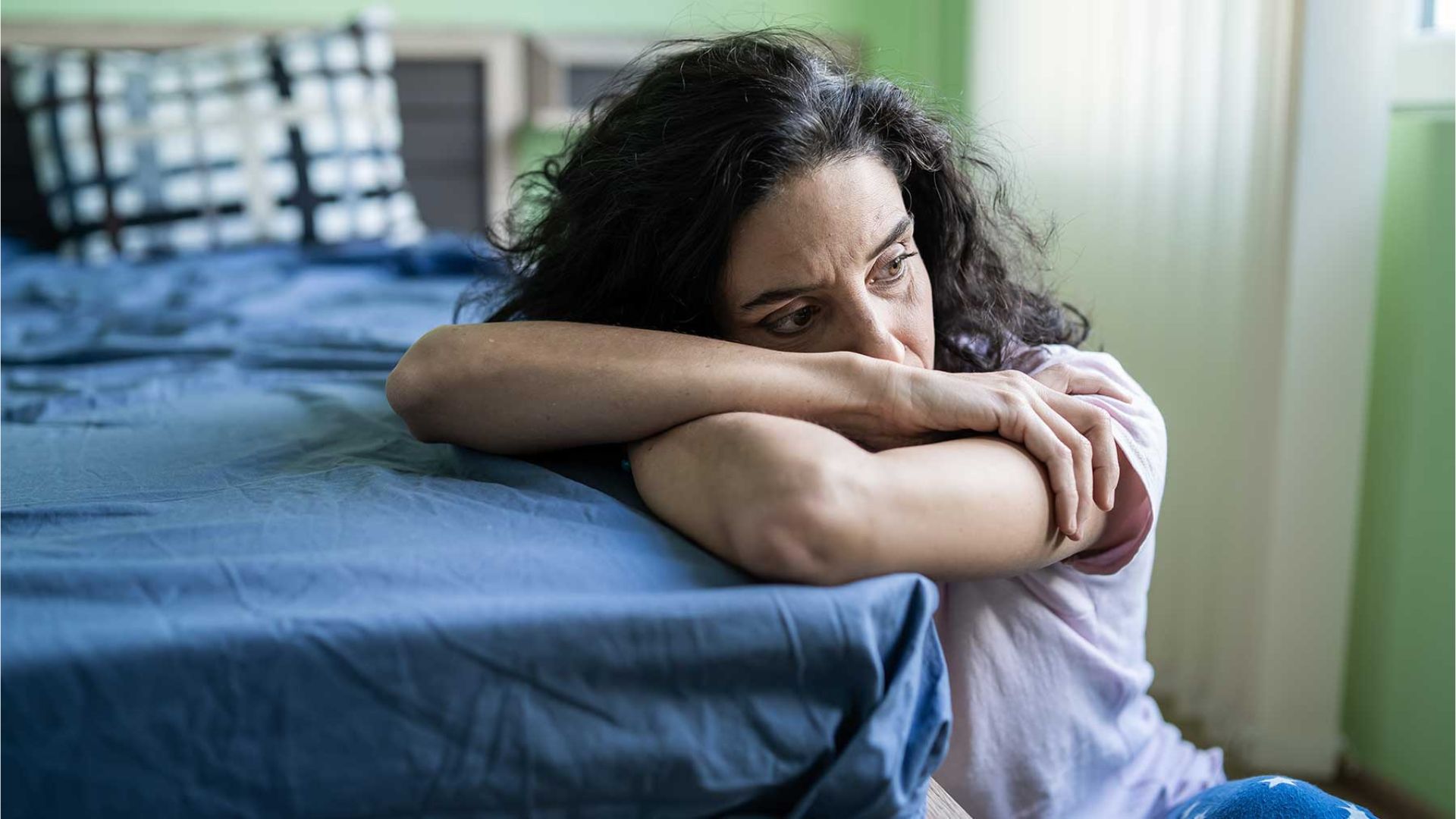 A Woman Crying While Leaning With Bed