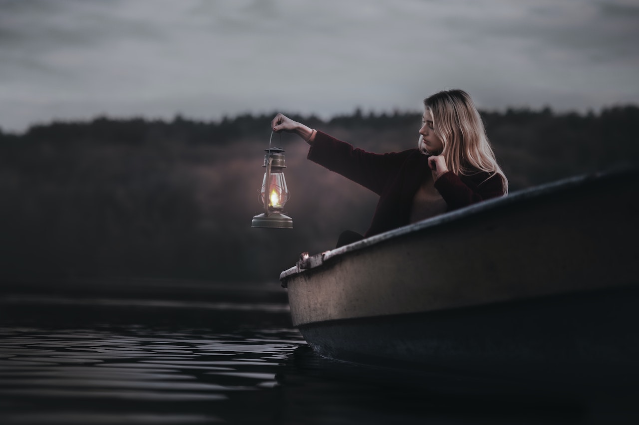 Woman On A Boat Holding a Lantern