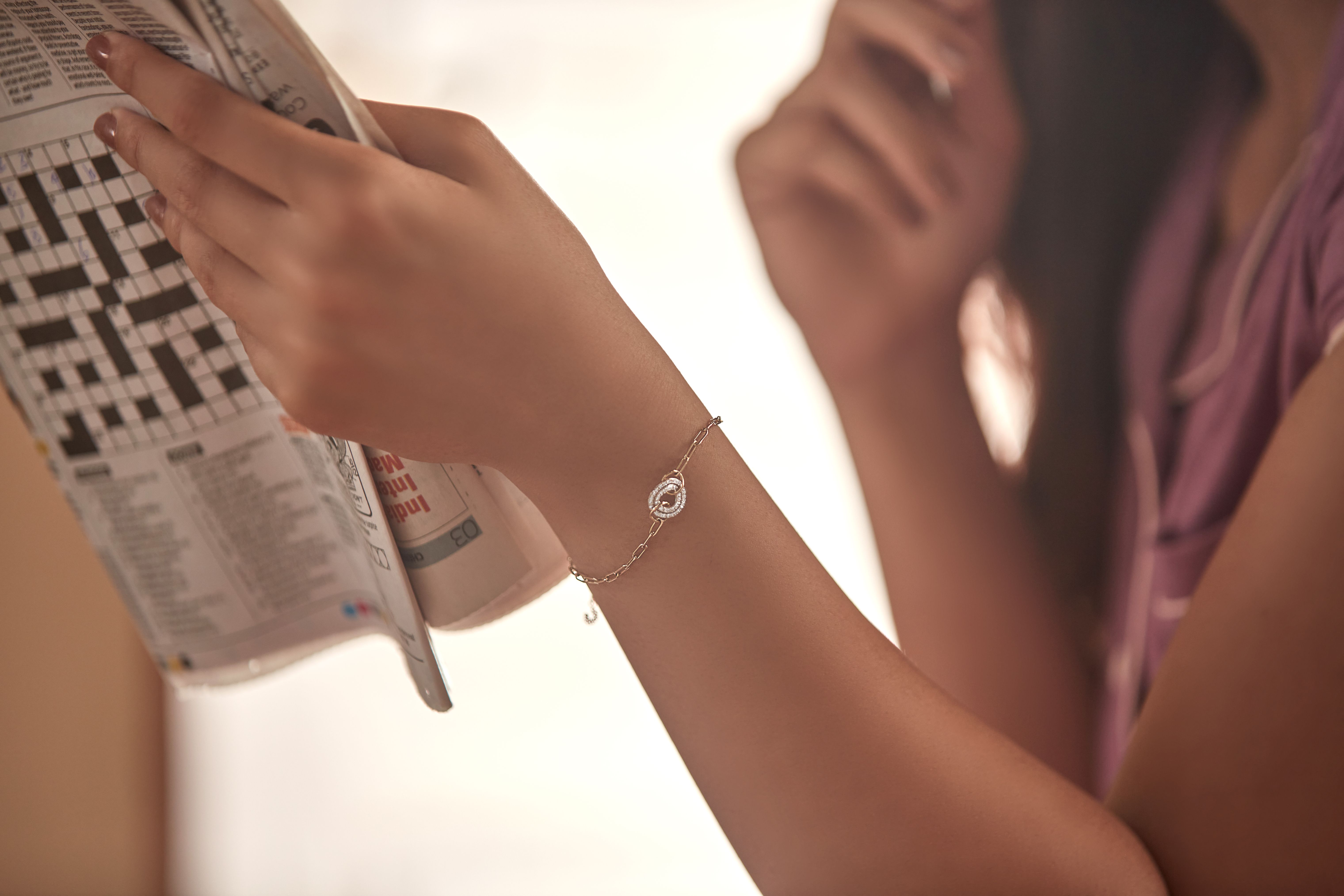 A Woman Wearing Heart Design Bracelet In Her Right Hand