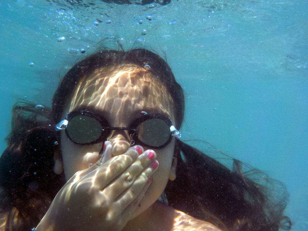 A Girl taking a dive underwater holding her breath