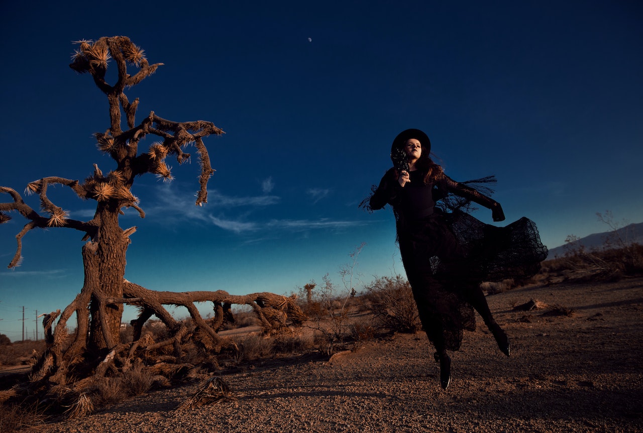Woman in a Steampunk Outfit beside a Joshua Tree