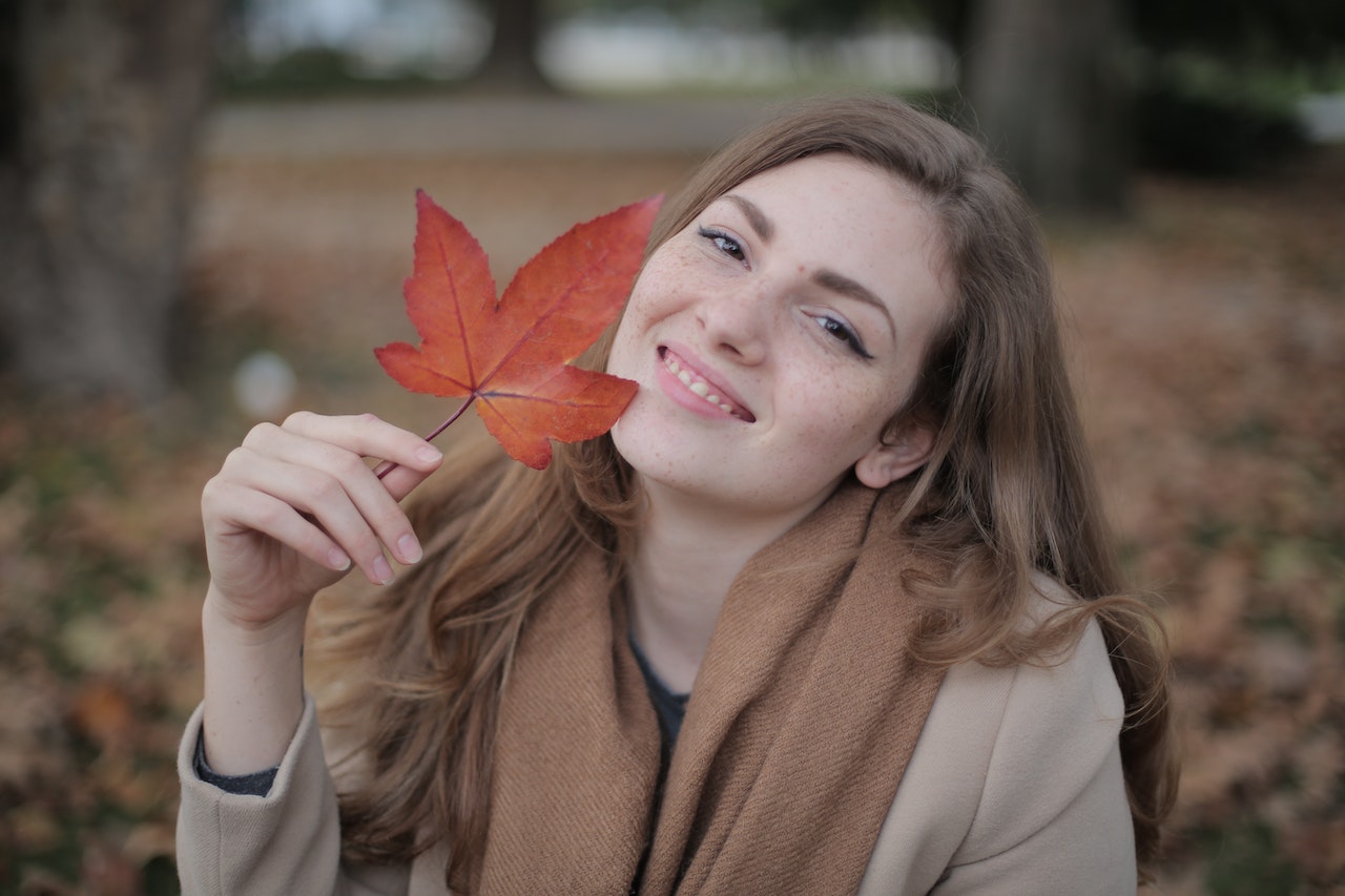 Woman Holding a Red Leaf