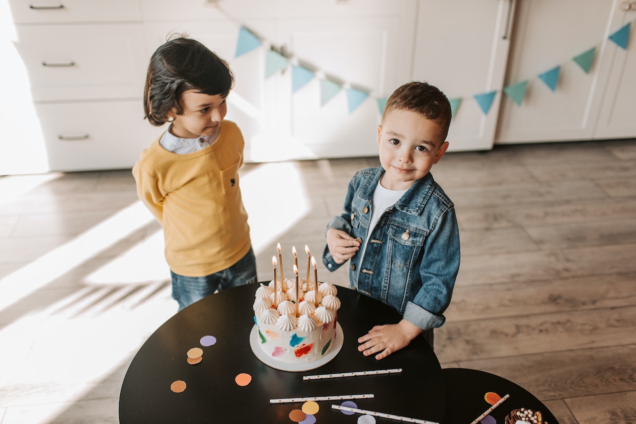A Boy in a Denim Jacket Near a Birthday Cake