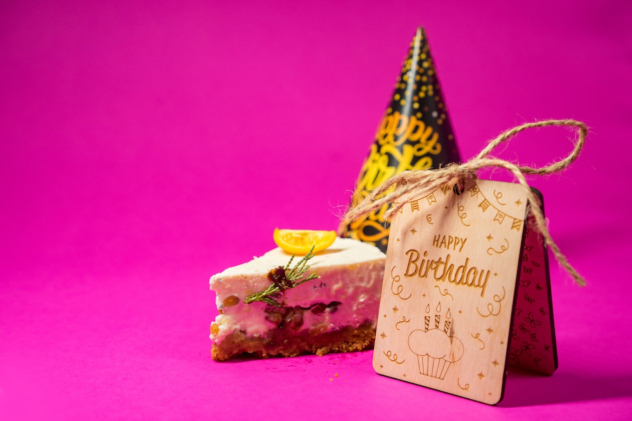A Slice of Birthday Cake on Pink Surface