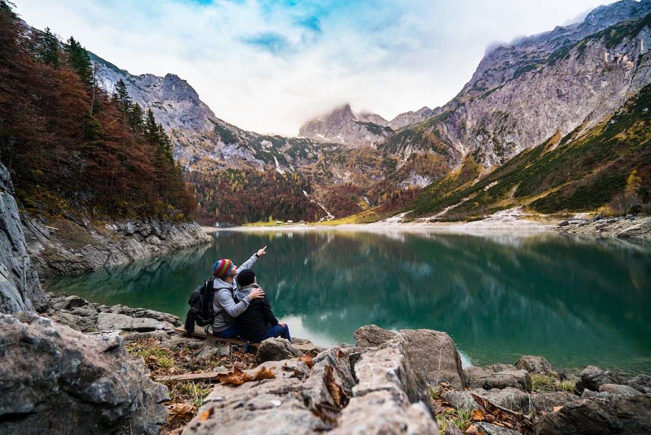 Couple Sitting on a Rock Beside Lake